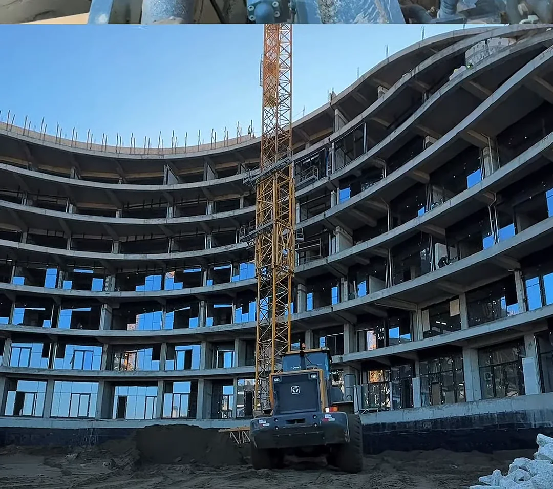 Каркас изнутри двора в январе 2025 года: ярусы изогнутых балконных плит, кран и погрузчик
