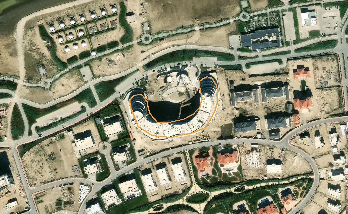 Спутник: оранжевый контур — здание Skyline по OpenStreetMap. Каркас подковы стоит, во дворе котлован, к северо-западу — купола кемпинга